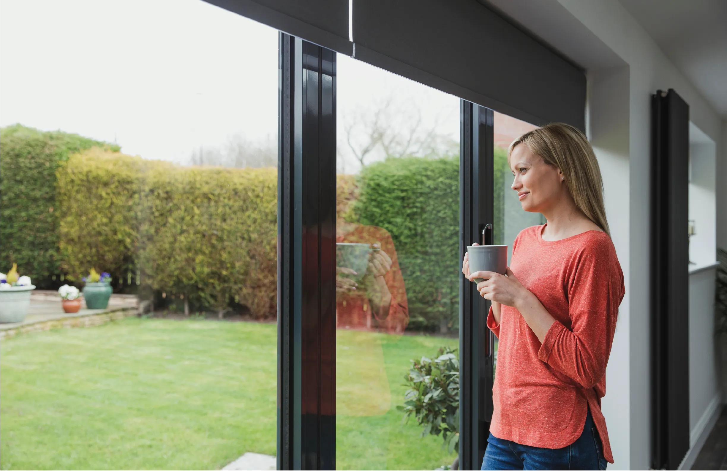 woman with coffee cup looking outside